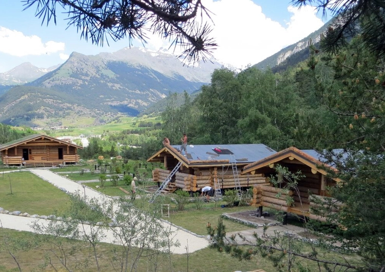 chantier de plusieurs chalets en région montagneuse, sur l'un des chantiers les ouvriers posent la membrane EPDM pour recevoir le système de végétalisation.