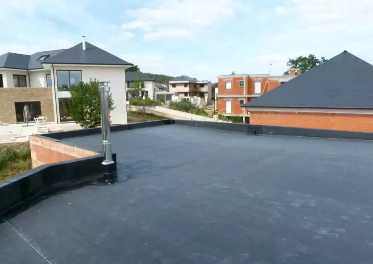toit plat couvert en EPDM, la construction est en brique, à gauche une platine de poele, au fond les immeubles voisins