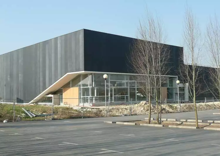 Bâtiment de collectivité avec membrane EPDM collé sur bardage acier double peau, parking et arbres au premier plan